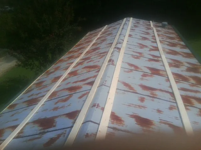 Rusted metal roof panels with new wood purlins before replacement — Storm Damage Roof Repair in Saint Ann by Roofing Brothers
